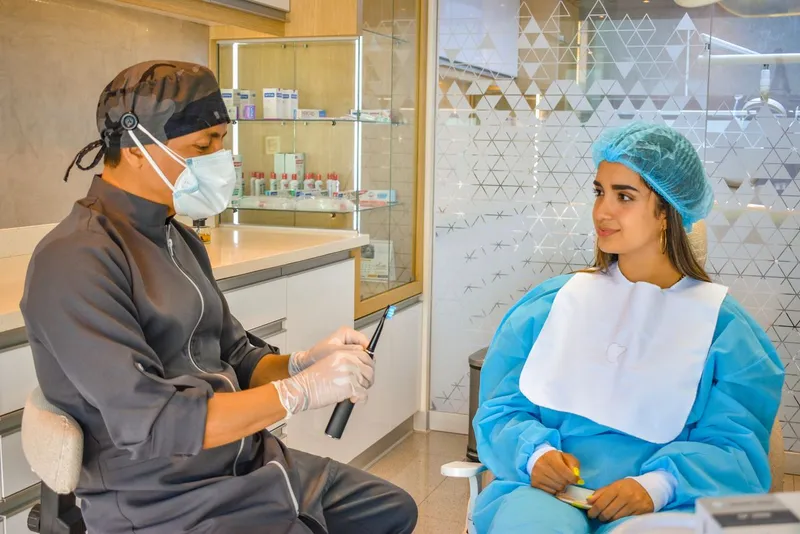 Dentist and patient reviewing a digital treatment plan at a consultation desk — the pre-travel consultation process at an accredited Antalya clinic serving UK patients