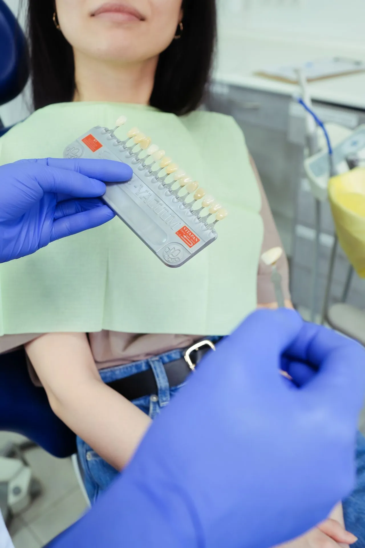 Dentist matching porcelain shade during a colour consultation — precision cosmetic planning at a top Turkey dental clinic